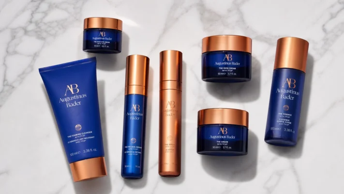 Augustinus Bader full skincare range flat lay on marble, minimalist luxury photography